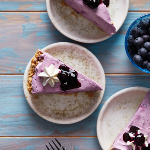 Slices of blueberry cheesecake plated on dessert plates