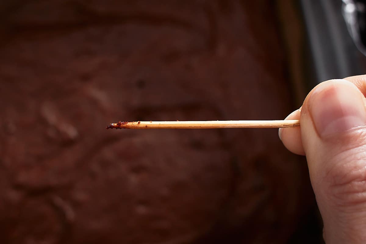 A slightly dirty toothpick with batter and cake crumbs attached