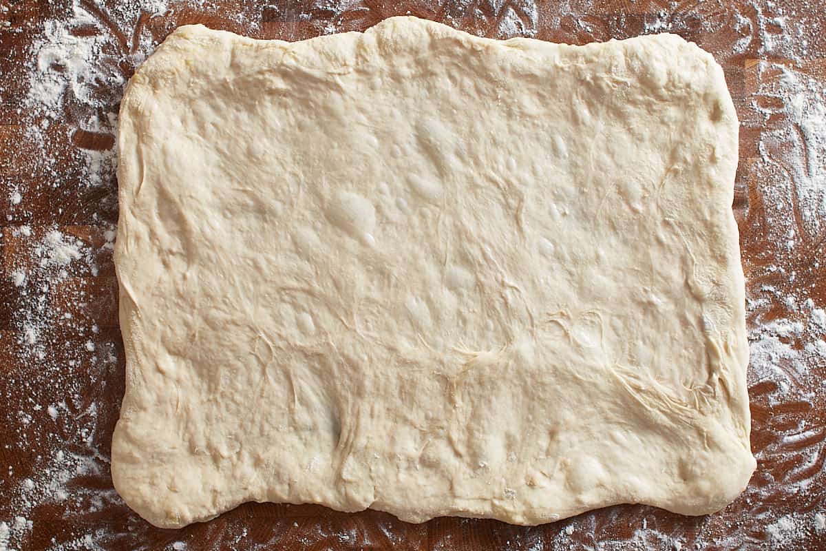 Stretched pizza dough on a work surface