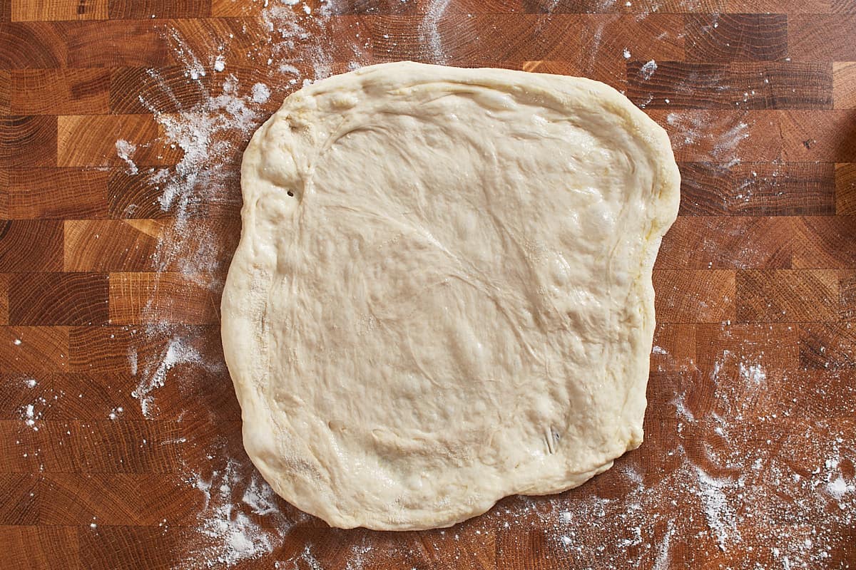 Stretched pizza dough on a floured work surface