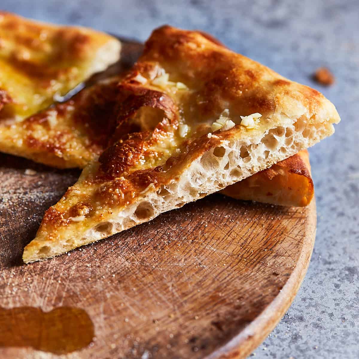 Close up of a slice of pizza to reveal the bubbly texture