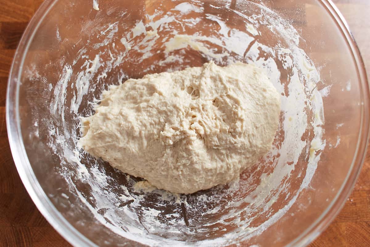 Kneaded pizza dough in a glass bowl