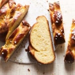 Sliced loaf of challah bread on a serving plate