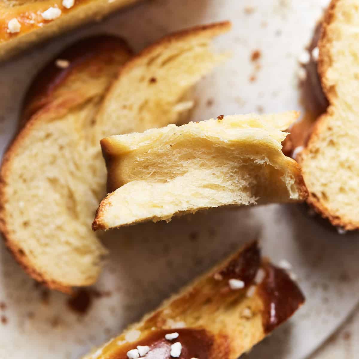 Torn slice of challah bread on a serving plate