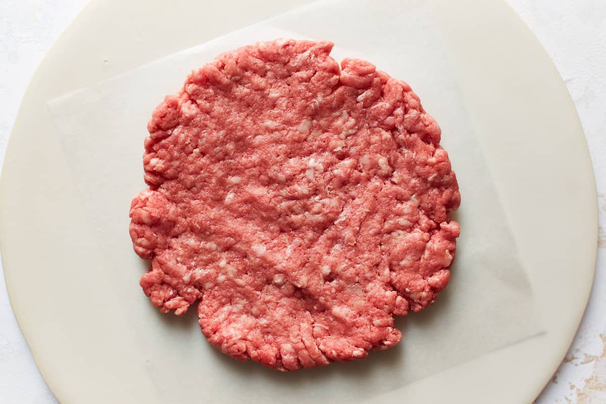 Flat pressed beef patty on a plate