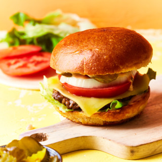 A prepared cheeseburger on a serving board