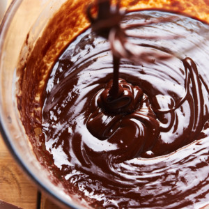Edible brownie batter dripping down a whisk into a bowl