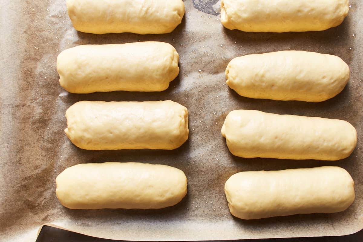 Proofed dough buns on a baking sheet
