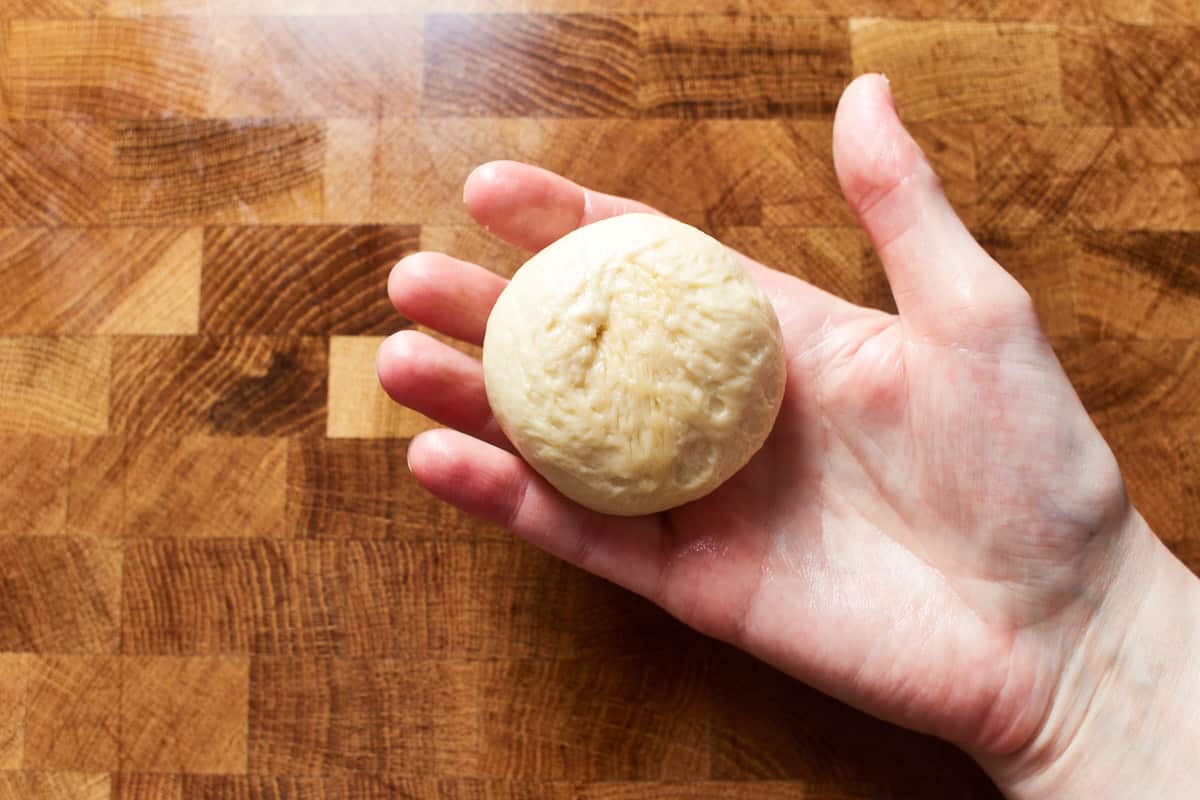 Holding a shaped piece of dough in the hand