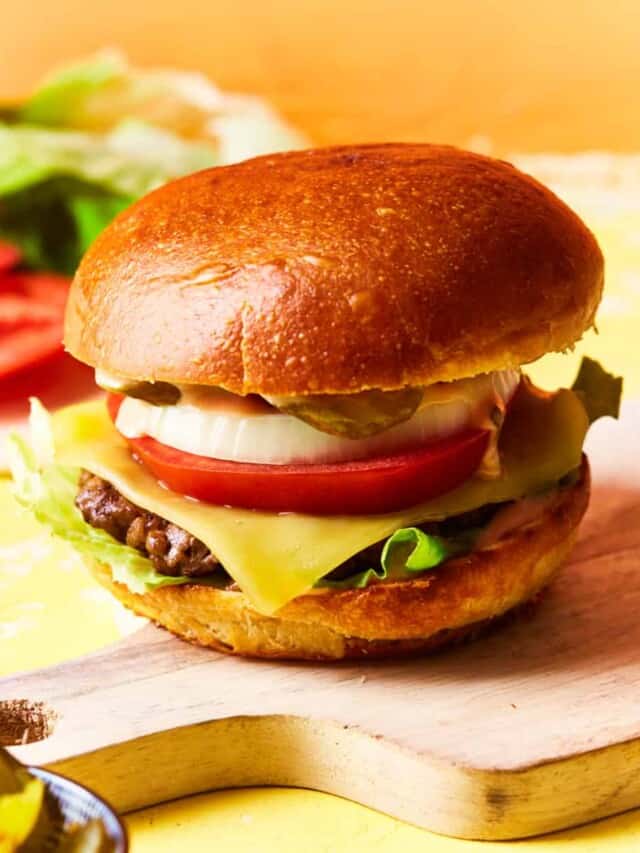 A prepared cheeseburger on a serving board