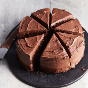 Sliced chocolate cake on a black cake plate