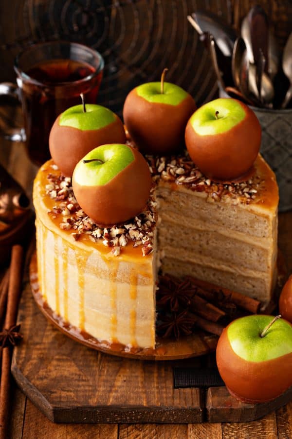Apple layer cake topped with caramel apples and nuts