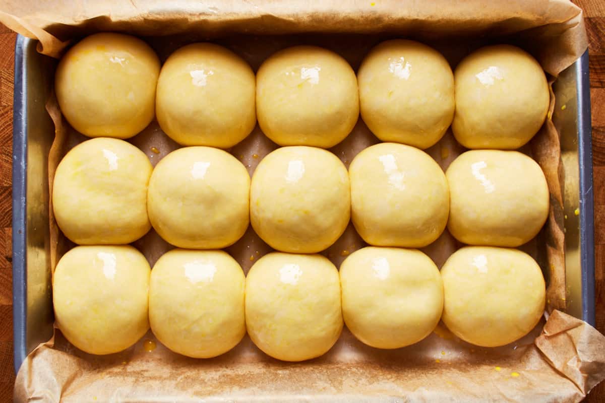 Risen balls of dough in a baking pan