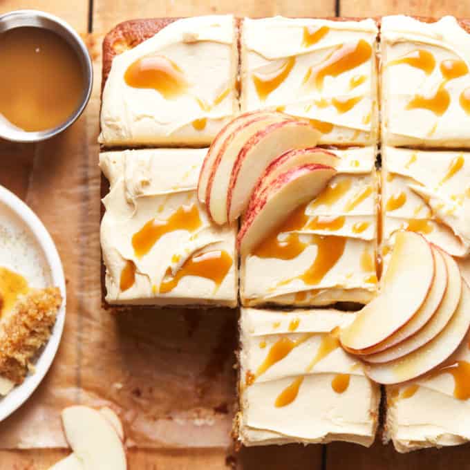 Sliced apple cake on a wooden table with caramel syrup and apple slices on top