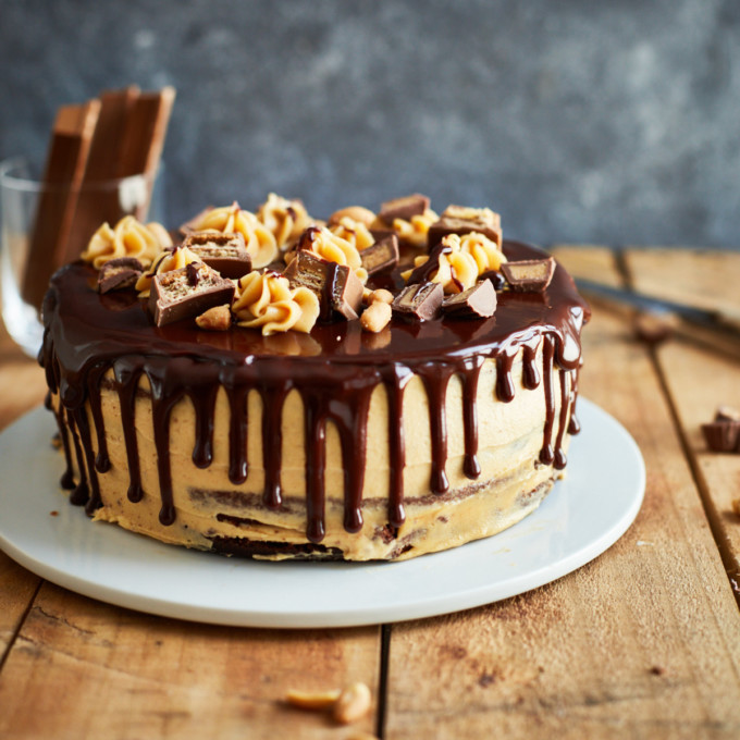Decorated chocolate cake with peanut butter frosting and chocolate ganache on a cake plate