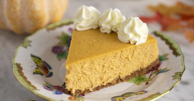 a slice of pumpkin cheesecake with whipped cream on top