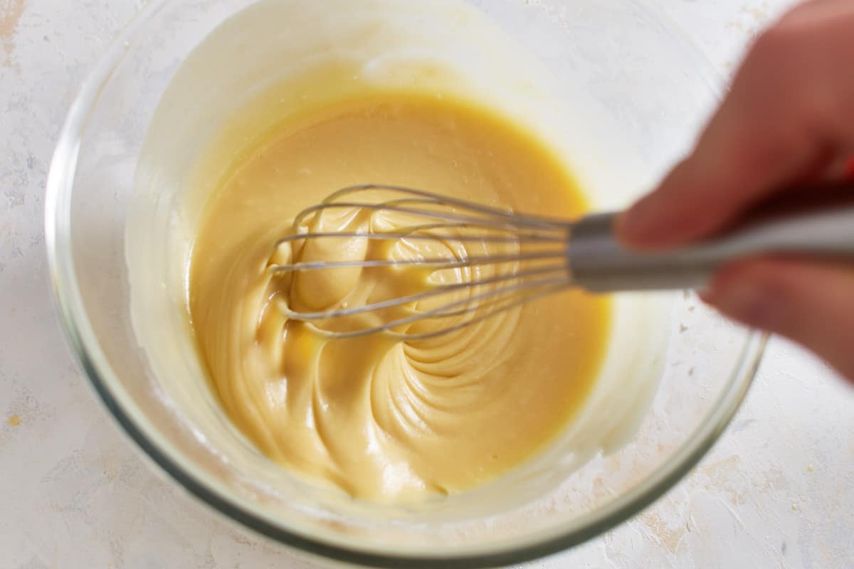 Whisking vanilla cake batter in a large mixing bowl