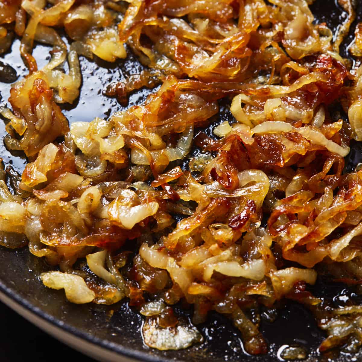 Fully caramelized deep-golden onions in a cast iron pan