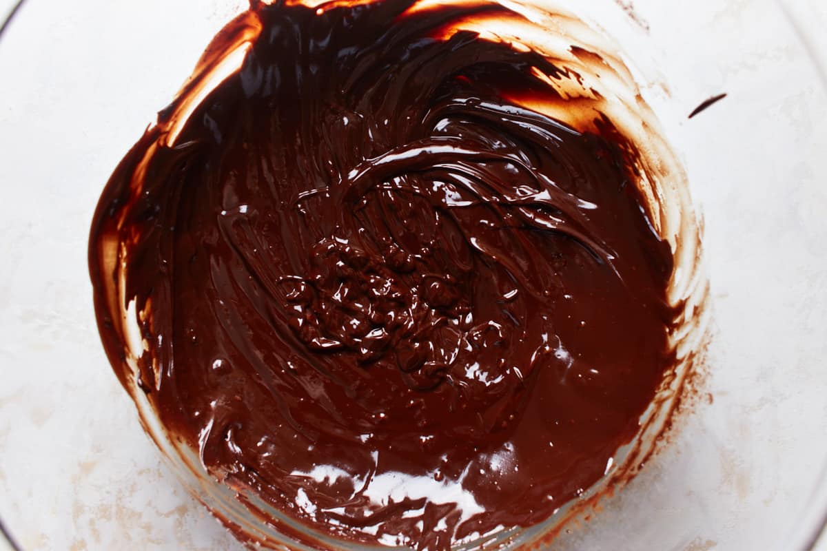 Melted butter and chocolate with cocoa powder stirred in in a bowl