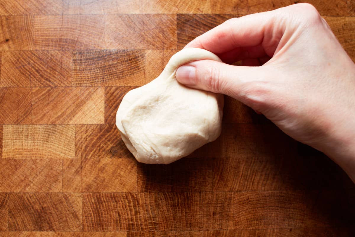 Stretching up some dough with two fingers