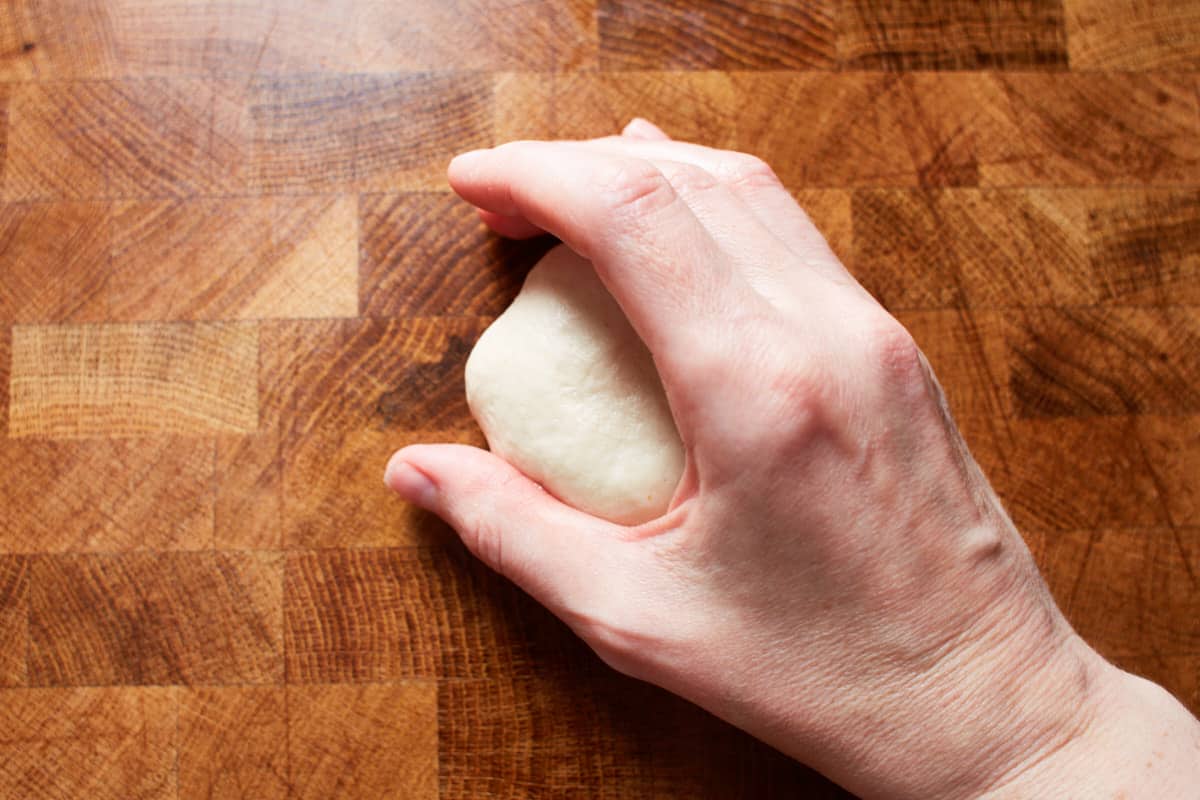 Cupping a piece of dough with a c-shaped hand