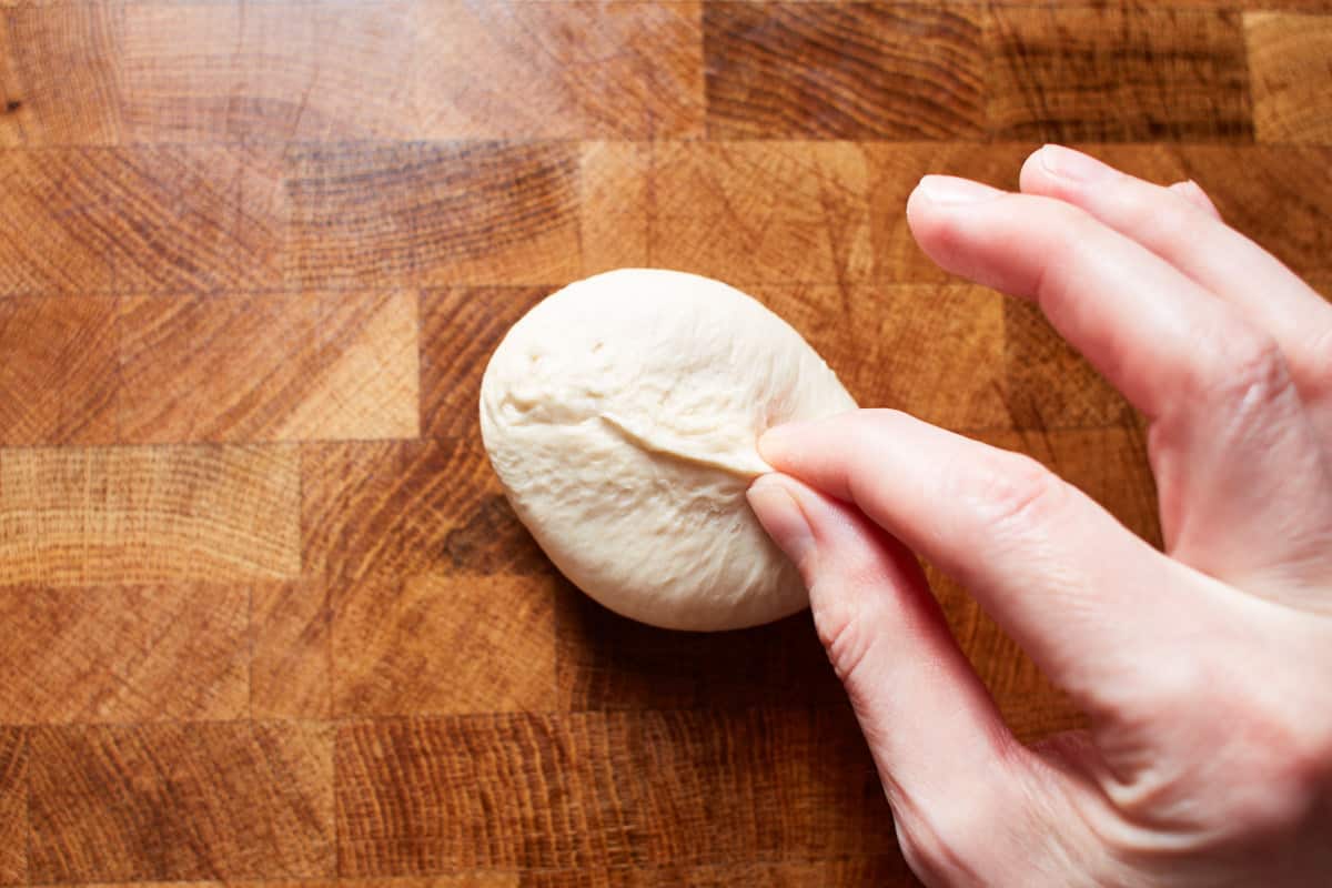 Pinching dough with two fingers to seal the seams