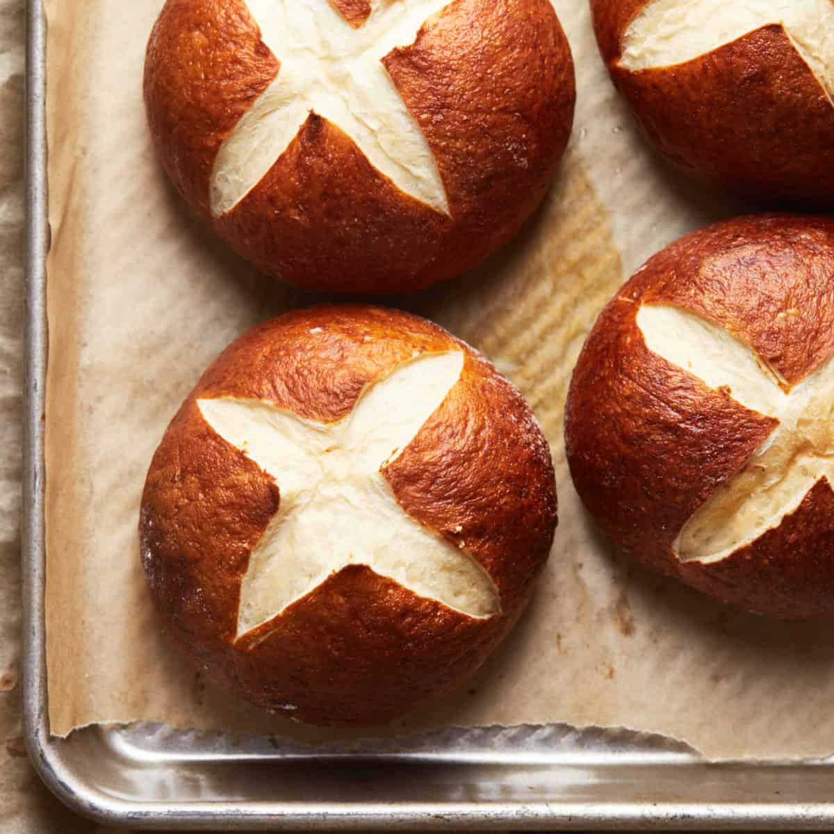 Top down view of baked pretzel buns on a baking sheet