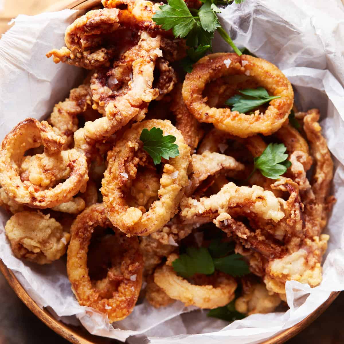 Fried calamari on a round tray with herbs
