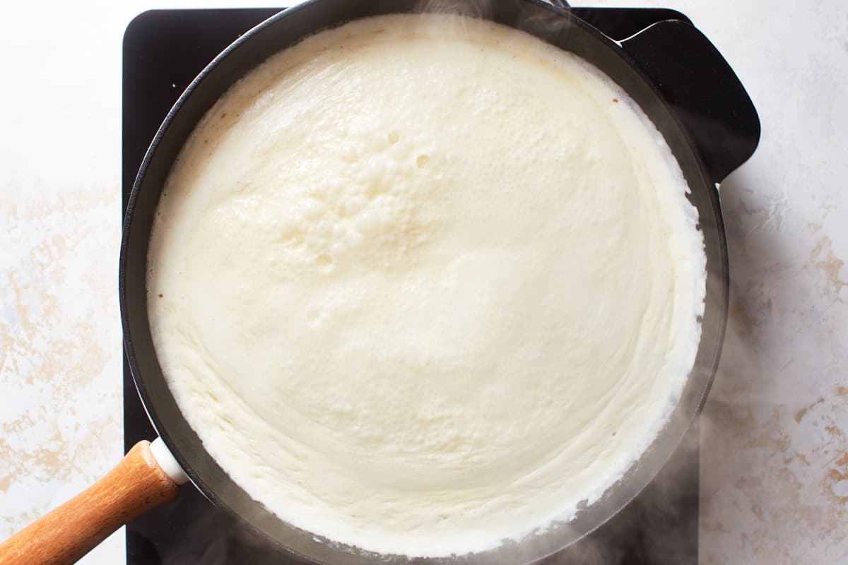Cream sauce cooking in a large skillet