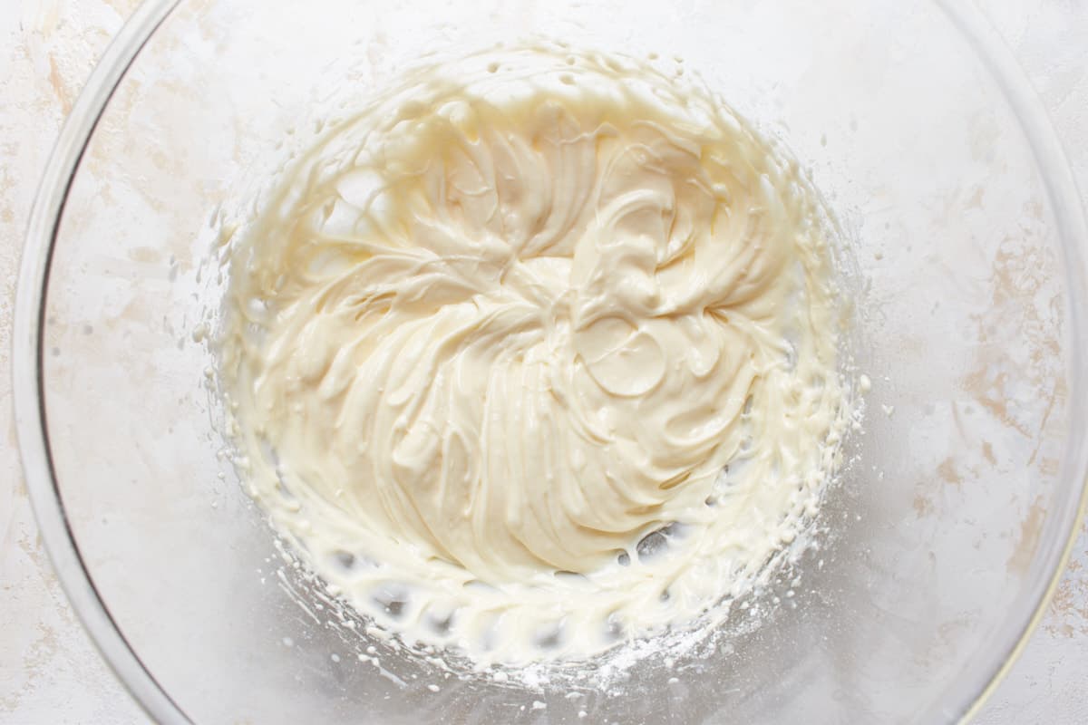 Mixed cream cheese frosting in a glass bowl
