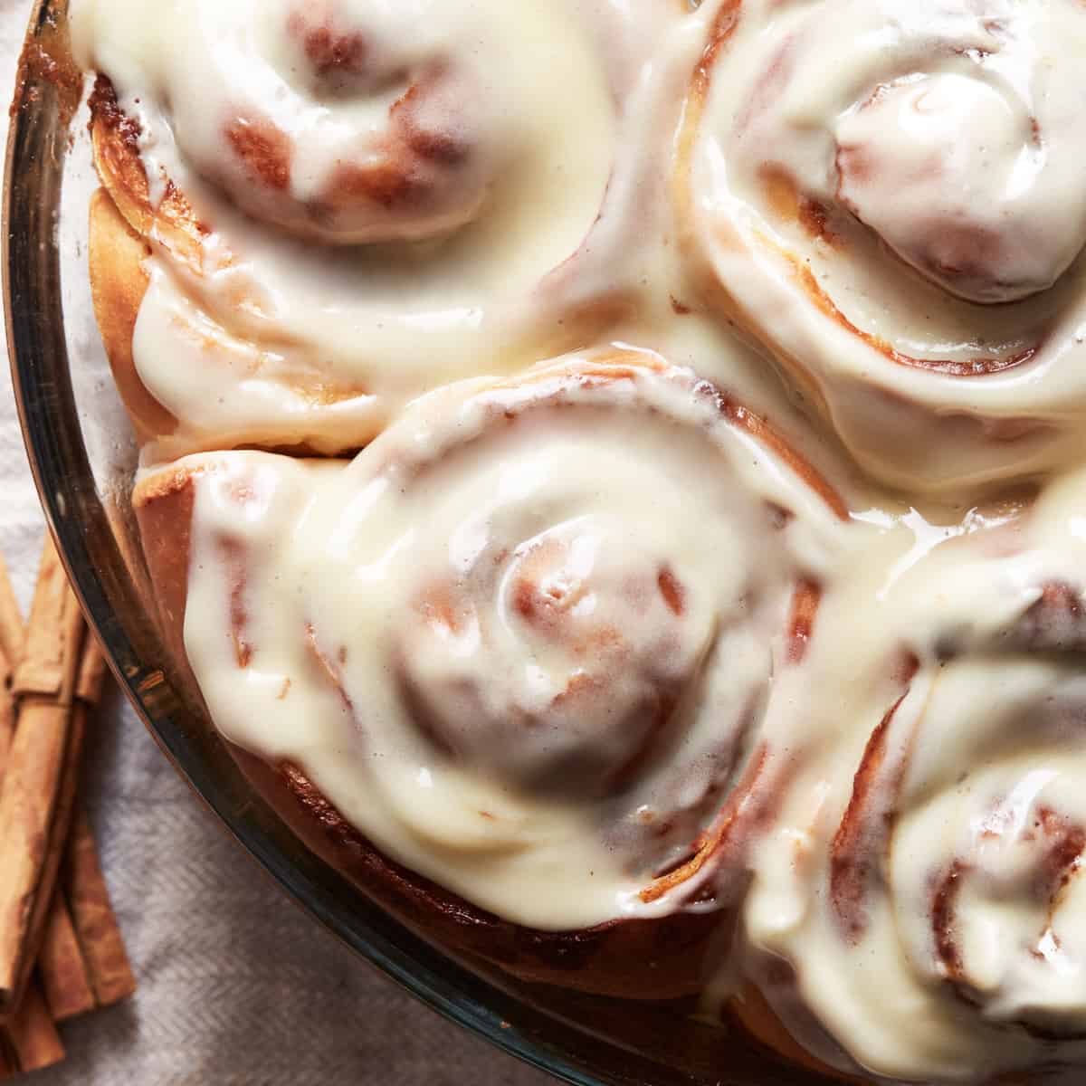 Baked cinnamon rolls topped with cream cheese frosting