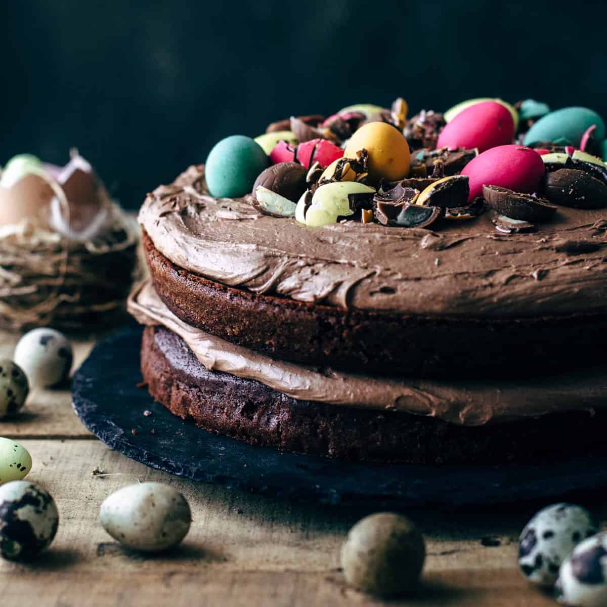 Two-layer chocolate cake with frosting decorated with chocolate eggs