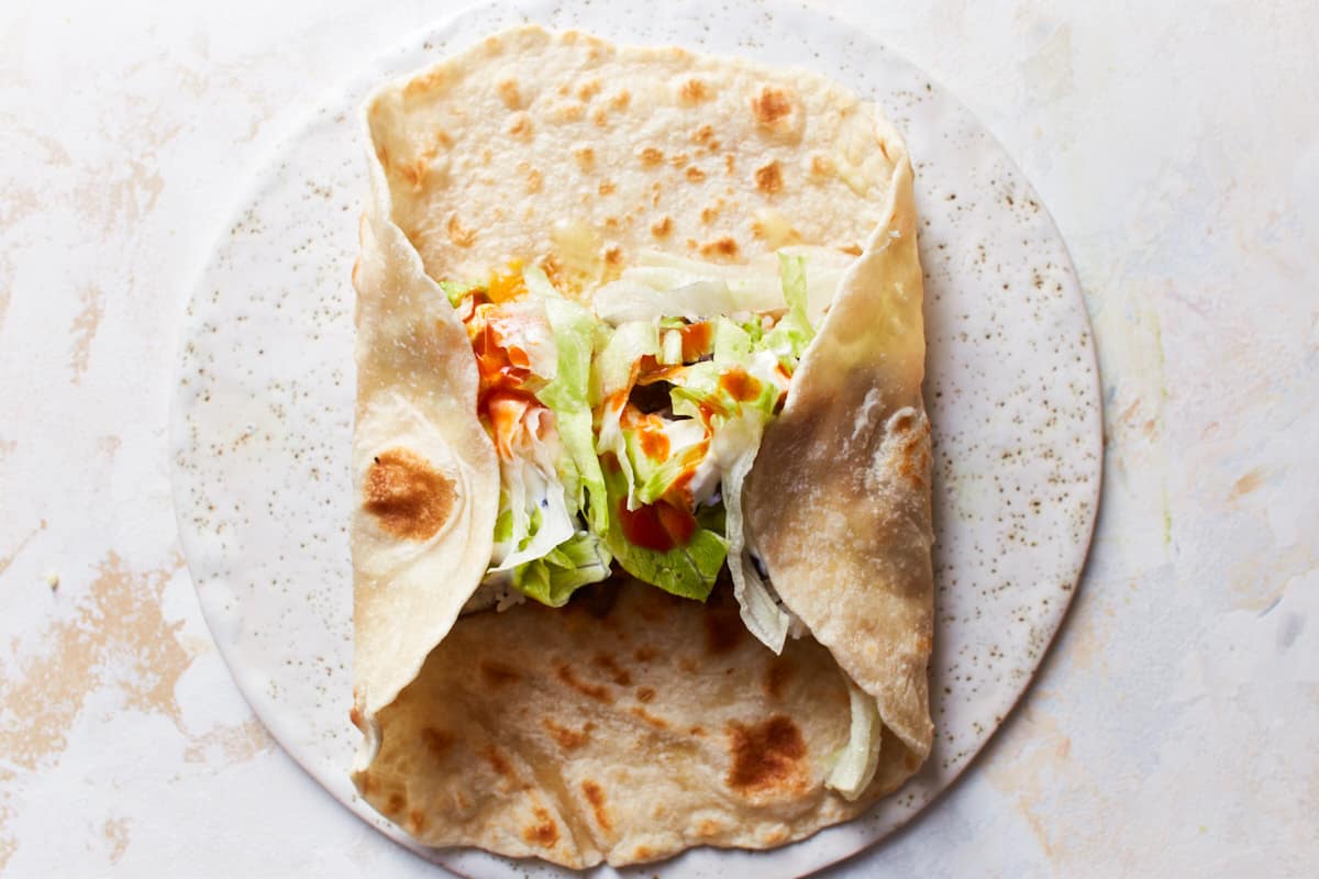 Half open tortilla wrap with two opposite sides folded over the filling