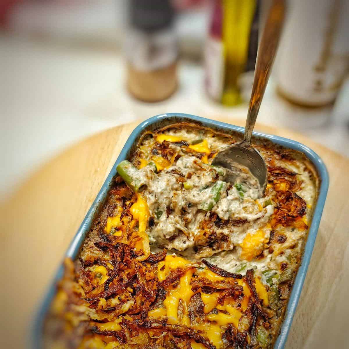 green bean casserole in a baking dish with spoon