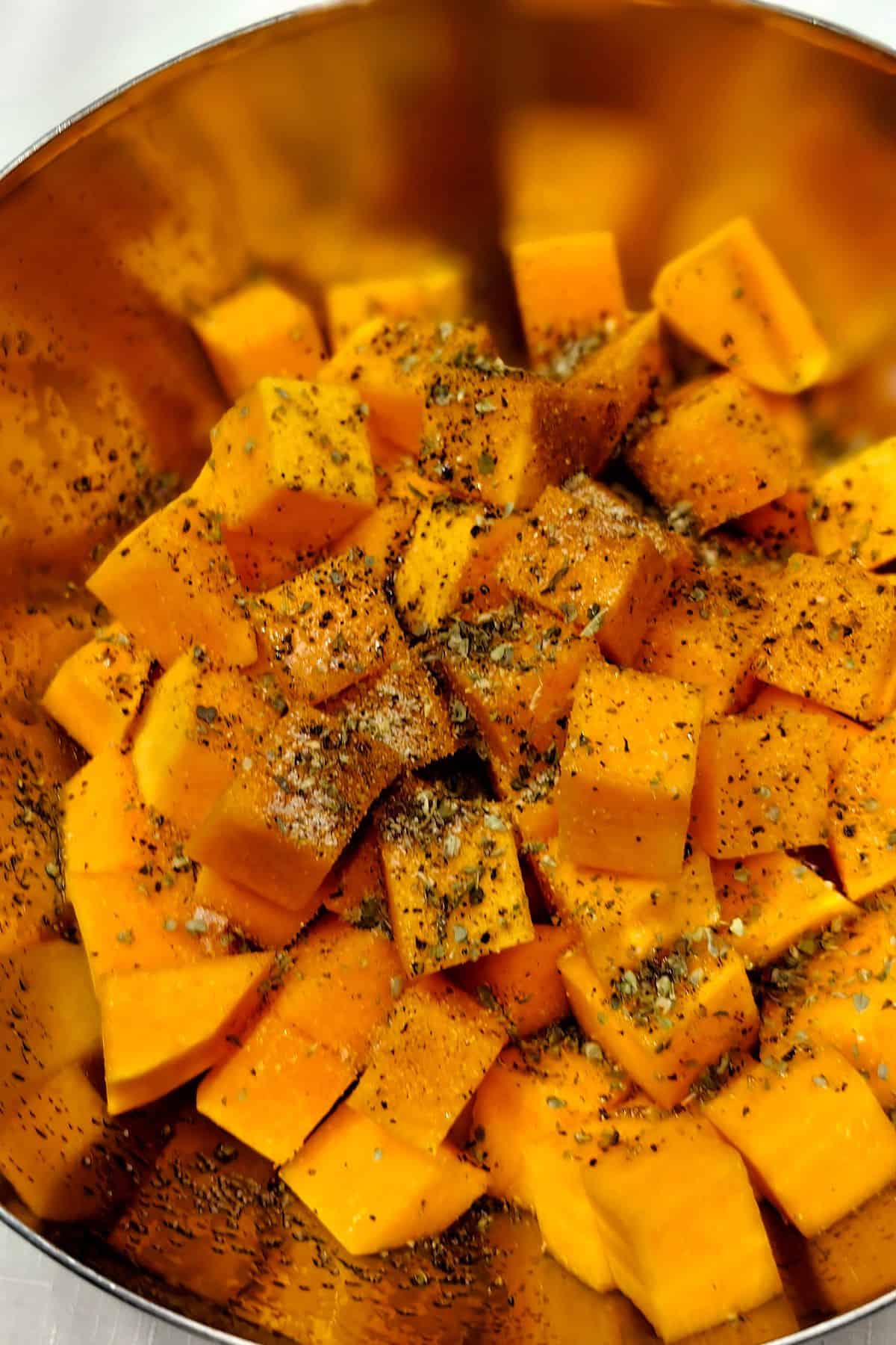 Pumpkin sprinkled with seasoning in a large dish
