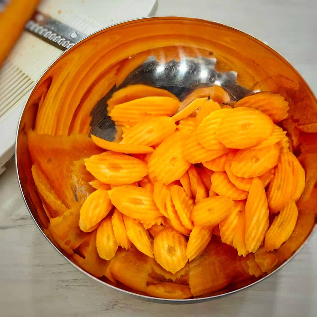 peeled and sliced carrot chips in a mixing bowl