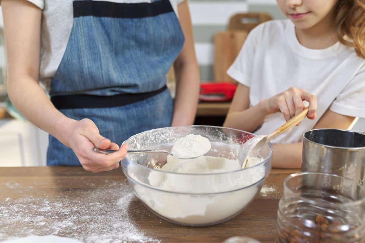 children mix flour and powdered egg replacer in bowl