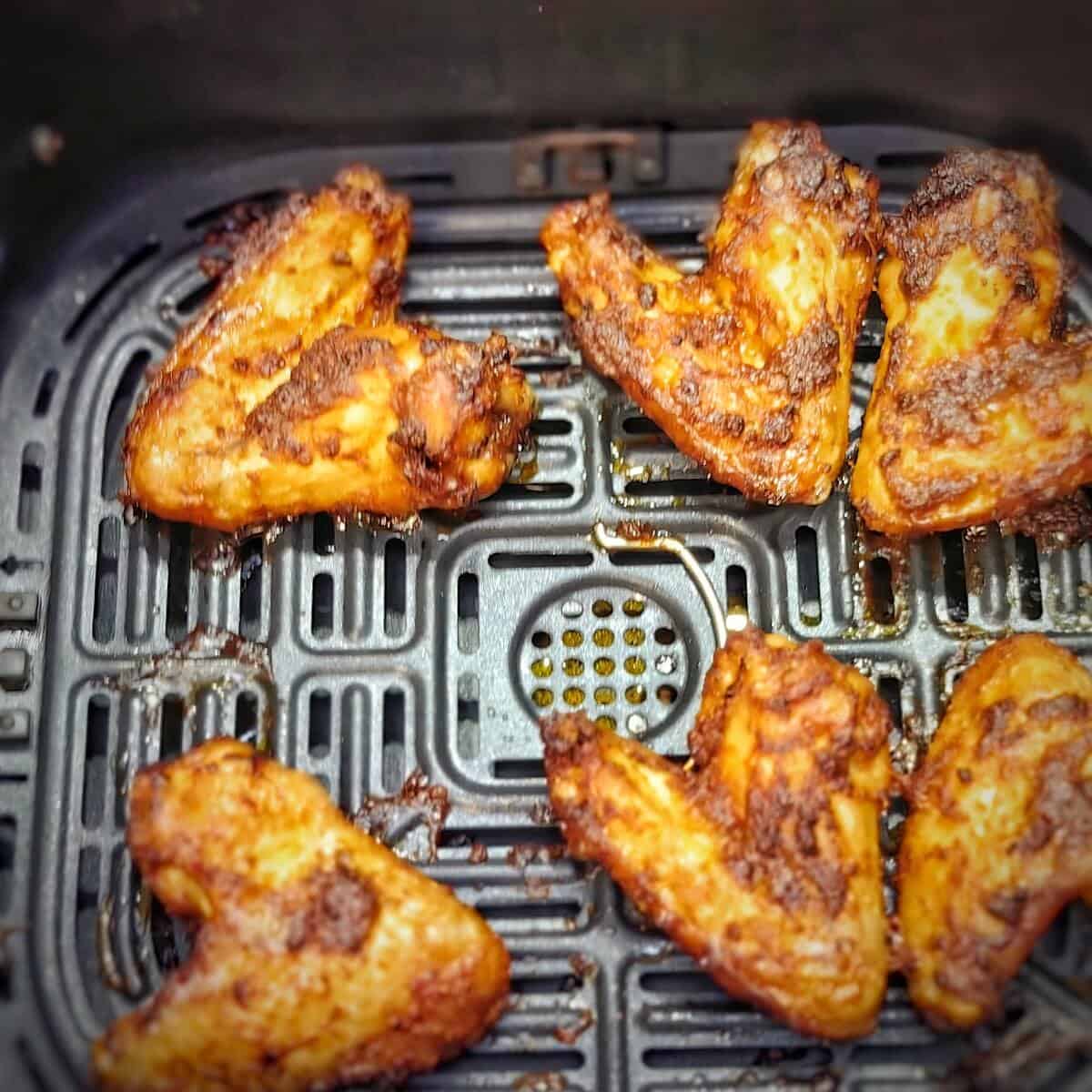 cooked chicken wings in the air fryer basket