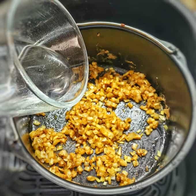 pouring water into air fryer container