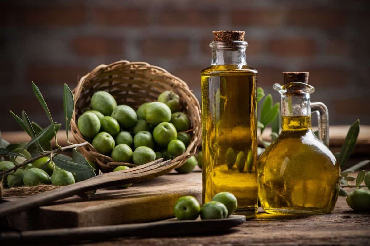 bottles of olive oil and basket of olives