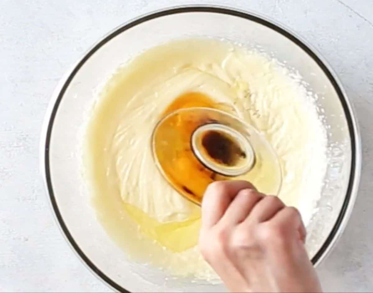 adding large eggs and vanilla extract to cake batter