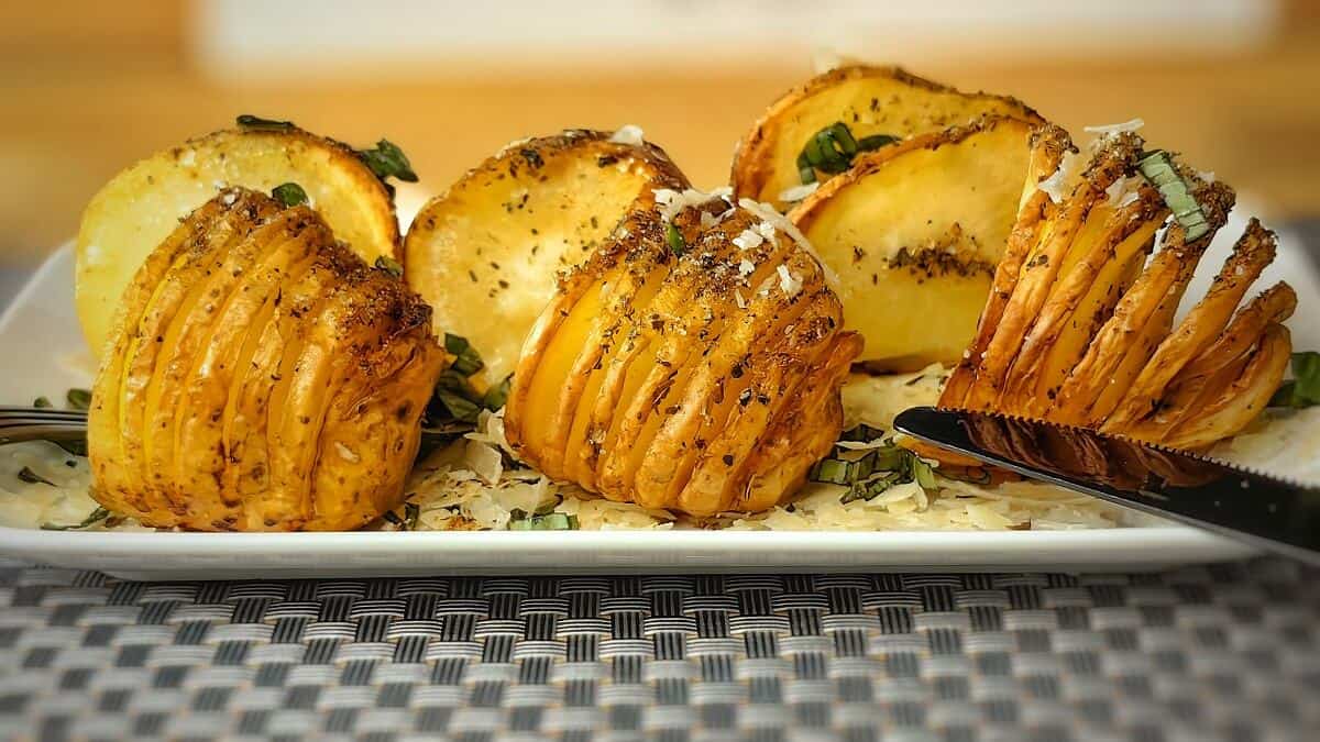 air fryer hasselback potatoes on a serving plate with knife