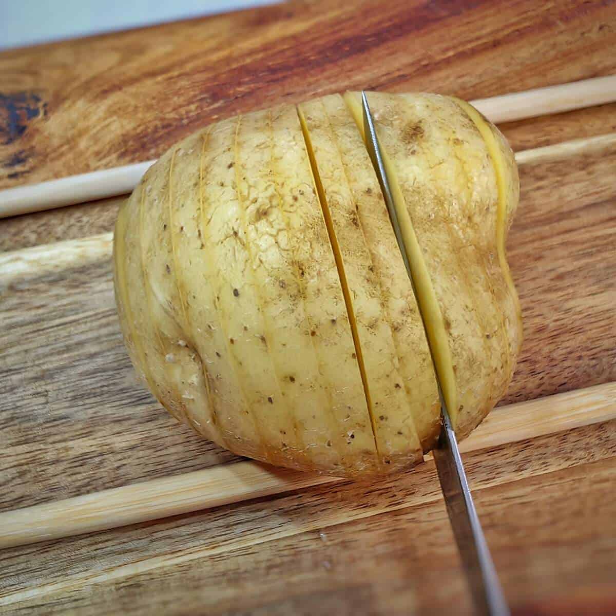 slicing potatoes with chopstick on either side