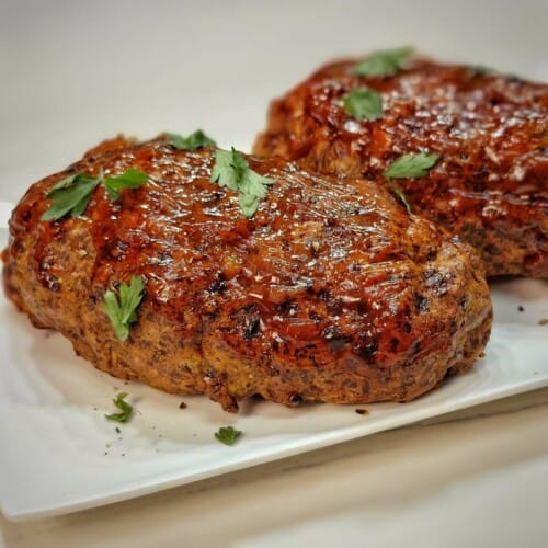 air fryer meatloaf on a white serving plate with parsley as garnish