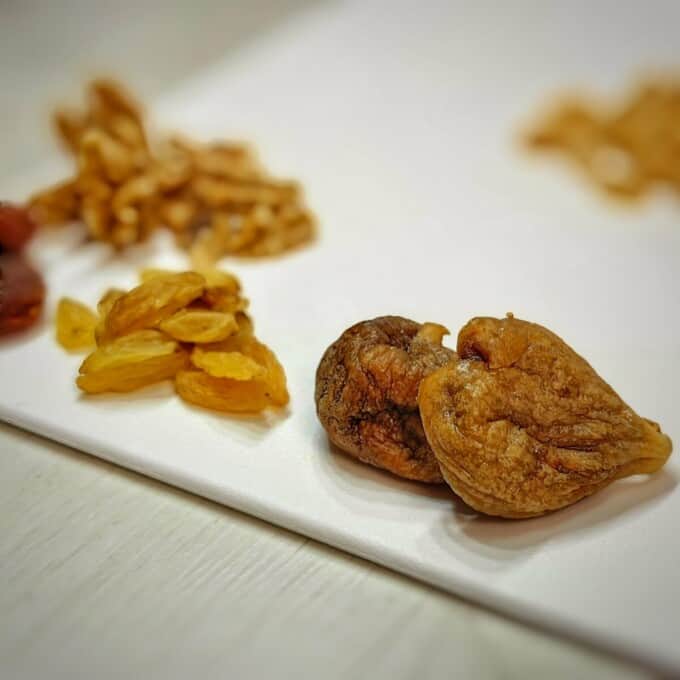 different dried fruits and nuts on a chopping board