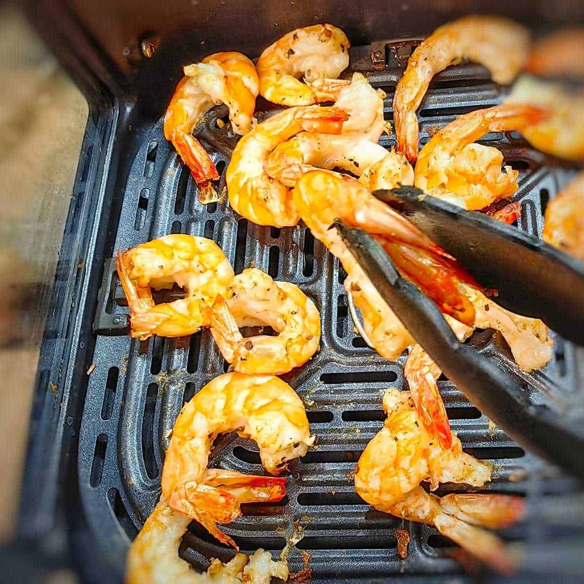 shrimp in kitchen tongs