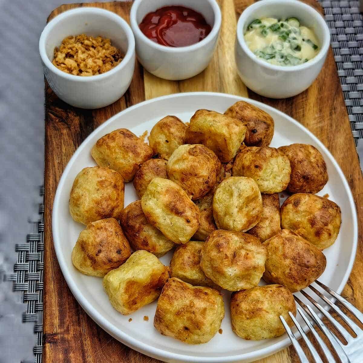 air fryer tater tots on top of chopping board with different dips
