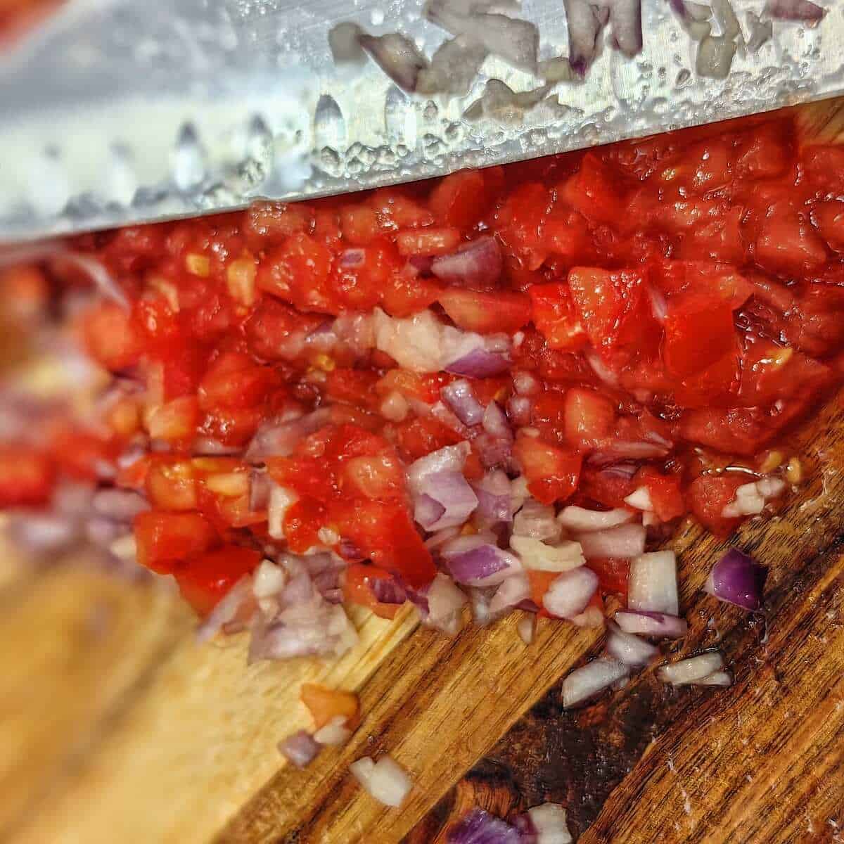 diced red onion and tomato with knife