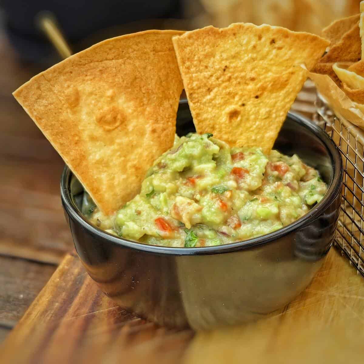 air fryer tortilla chips on a bowl of guacamole
