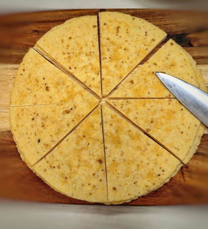 sliced wheat tortilla on top of of a chopping board with knife